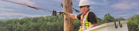 Installer inspecting fiber cables in a lift bucket