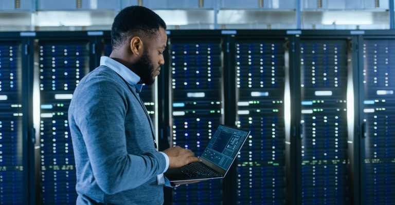 Man holding computer in data center