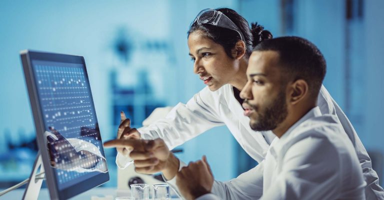 Two scientists analysing information on a monitor